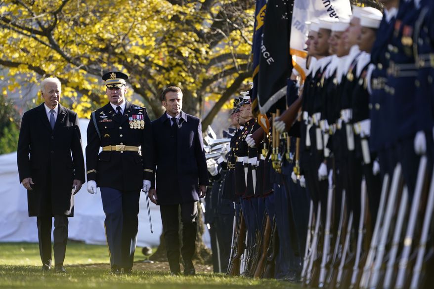 President Joe Biden and French President Emmanuel Macron review the troops with Col. David Rowland, commander of the 3rd U.S. Infantry Regiment, The Old Guard, during a State Arrival Ceremony on the South Lawn of the White House in Washington, Thursday, Dec. 1, 2022. (AP Photo/Andrew Harnik)