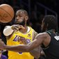 Los Angeles Lakers forward LeBron James, left, passes the ball as Portland Trail Blazers forward Justise Winslow defends during the first half of an NBA basketball game Wednesday, Nov. 30, 2022, in Los Angeles. (AP Photo/Mark J. Terrill)