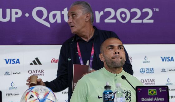 Brazil&#39;s Dani Alves, front, head coach Tite attend a press conference on the eve of the group G of World Cup soccer match between Brazil and Cameroon in Doha, Qatar, Thursday, Dec. 1, 2022. (AP Photo/Andre Penner)