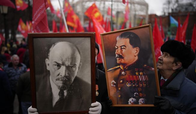 Communist party supporters hold portraits of Josef Stalin and Vladimir Lenin as they gather during the national celebration of the &amp;quot;Defender of the Fatherland Day&amp;quot; near the Kremlin in Moscow&#x27;s Revolution Square on Feb. 23, 2022. (AP Photo/Alexander Zemlianichenko)
