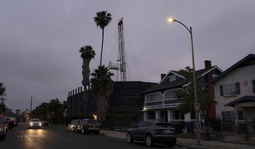 A vehicle drives past the Jefferson oil drill site located in the residential area in Los Angeles, June 2, 2021. The Los Angeles City Council voted on Friday, Dec. 2, 2022, unanimously to ban new oil and gas drill sites and phase out existing ones over the next 20 years on Friday. (AP Photo/Jae C. Hong, File)