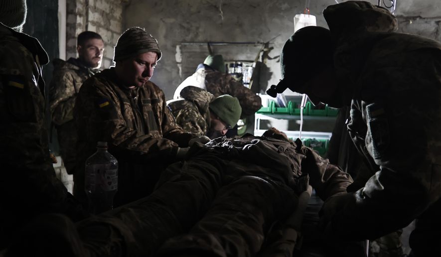 Ukrainian servicemen give the first aid to a soldier wounded in a battle with the Russian troops in their shelter in the Donetsk region, Ukraine, Thursday, Dec. 1, 2022. A top adviser to Ukraine&#x27;s president has cited military chiefs as saying 10,000 to 13,000 Ukrainian soldiers have been killed in the country&#x27;s nine-month struggle against Russia&#x27;s invasion, a rare comment on such figures and far below estimates of Ukrainian casualties from Western leaders. (AP Photo/Roman Chop)