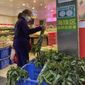 A woman shops in a reopened grocery store in the district of Haizhu as pandemic restrictions are eased in southern China&#39;s Guangzhou province, Thursday, Dec. 1, 2022. More Chinese cities eased some anti-virus restrictions as police patrolled their streets to head off protests Thursday while the ruling Communist Party prepared for the high-profile funeral of late leader Jiang Zemin. (AP Photo)