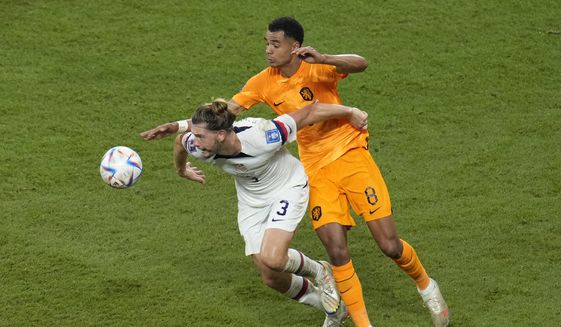 Walker Zimmerman of the United States, left, fights for the ballwith Cody Gakpo of the Netherlands during the World Cup round of 16 soccer match between the Netherlands and the United States, at the Khalifa International Stadium in Doha, Qatar, Saturday, Dec. 3, 2022. (AP Photo/Ricardo Mazalan)