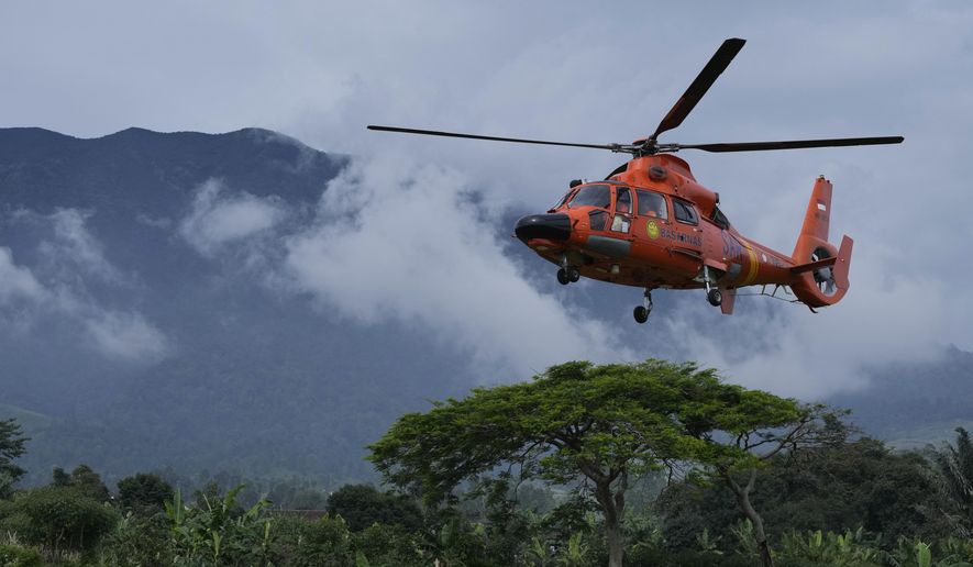 Members of the National Search and Rescue Agency (BASARNAS) flies a helicopter to deliver relief goods to a village affected by Monday&#39;s earthquake in Cianjur, West Java, Indonesia, Saturday, Nov. 26, 2022. The magnitude 5.6 quake killed hundreds of people, many of them children, and displaced tens of thousands. (AP Photo/Achmad Ibrahim)