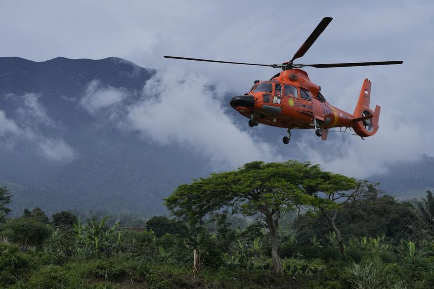 Members of the National Search and Rescue Agency (BASARNAS) flies a helicopter to deliver relief goods to a village affected by Monday&#x27;s earthquake in Cianjur, West Java, Indonesia, Saturday, Nov. 26, 2022. The magnitude 5.6 quake killed hundreds of people, many of them children, and displaced tens of thousands. (AP Photo/Achmad Ibrahim)