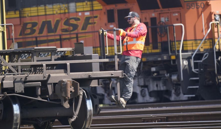 A worker rides a rail car at a BNSF rail crossing in Saginaw, Texas, Wednesday, Sept. 14, 2022. Most railroad workers weren&#x27;t surprised that Congress intervened this week to block a railroad strike, but they were disappointed because they say the deals lawmakers imposed didn&#x27;t do enough to address their quality of life concerns about demanding schedules and the lack of paid sick time.  (AP Photo/LM Otero, File)