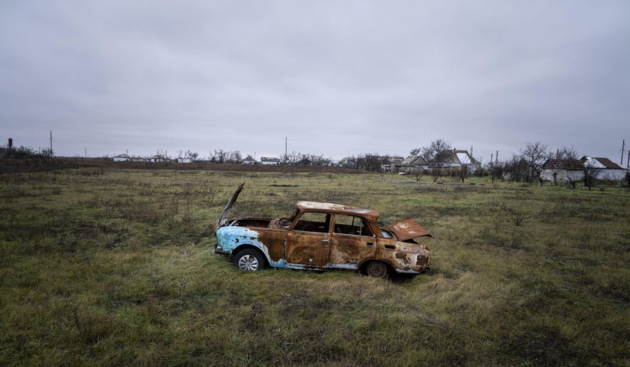 A car destroyed by Russian shelling sits in a field in Posad-Pokrovske village, in the Kherson region, Ukraine, Friday, Dec. 2, 2022. (AP Photo/Evgeniy Maloletka)
