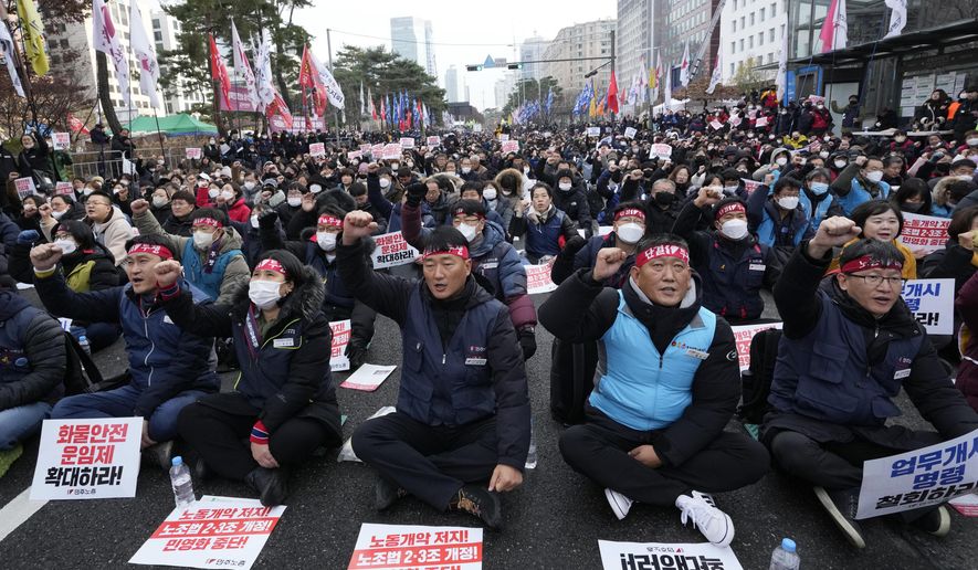 Members of the Korean Confederation of Trade Unions shout slogans during a rally against the government's labor policy near the National Assembly in Seoul, South Korea, Saturday, Dec. 3, 2022. Thousands of demonstrators representing organized labor marched in South Korea's capital on Saturday denouncing government attempts to force thousands of striking truckers back to work after they walked out in a dispute over the price of freight. (AP Photo/Ahn Young-joon)
