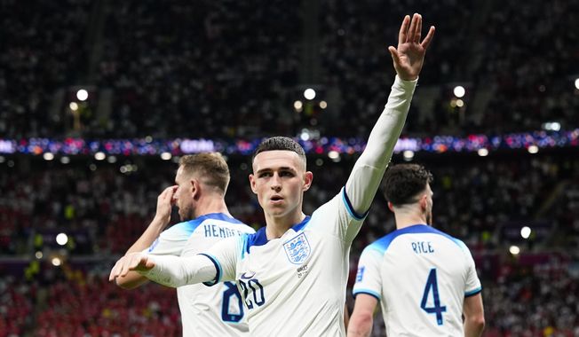England&#x27;s Phil Foden waves towards the fans after scoring his side&#x27;s second goal during the World Cup group B soccer match between England and Wales, at the Ahmad Bin Ali Stadium in Al Rayyan, Qatar, Tuesday, Nov. 29, 2022. (AP Photo/Pavel Golovkin)