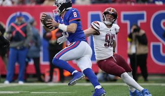 Washington Commanders&#39; Casey Toohill, right, tries to stop New York Giants quarterback Daniel Jones during the second half of an NFL football game, Sunday, Dec. 4, 2022, in East Rutherford, N.J. (AP Photo/John Minchillo)