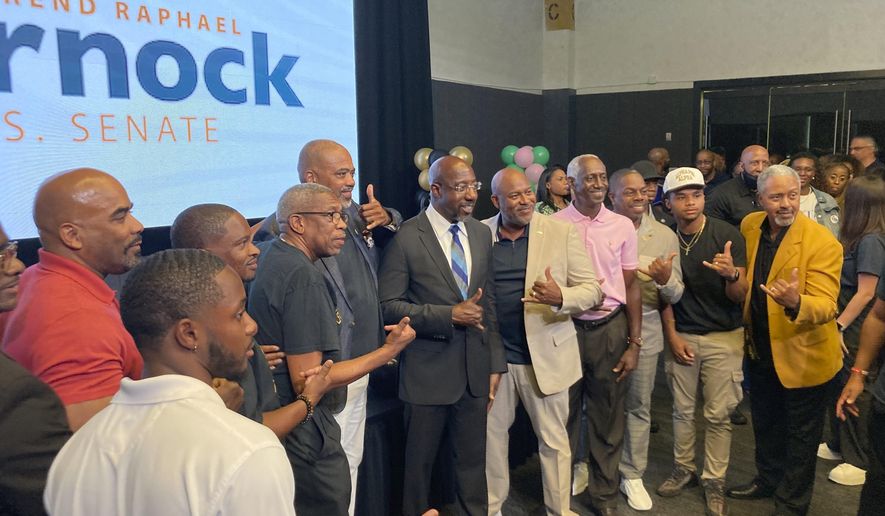 Georgia Sen. Raphael Warnock campaigns on Sept. 2, 2022, in Atlanta with other members of historically Black fraternities and sororities. Warnock faced Republican Herschel Walker, a former University of Georgia football star, in a Tuesday runoff. Sports and college loyalties have figure prominently in the contest and in other midterm campaigns in this closely divided Deep South battleground. (AP Photo/Bill Barrow)