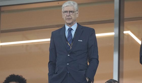 Former Arsenal coach Arsene Wenger stands on the tribune before the World Cup group G soccer match between Serbia and Switzerland, at the Stadium 974 in Doha, Qatar, Friday, Dec. 2, 2022. (AP Photo/Martin Meissner)