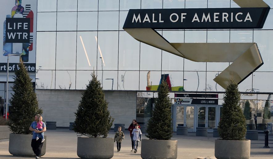 Shoppers, visitors and employees exit the Mall of America on March 17, 2020 as the mall in Bloomington, Minn. The family of a boy who was severely injured when he was thrown off a third-floor balcony at the Mall of America in April 2019 has reached a confidential settlement with the shopping center, which includes making changes to its trespassing policies, the family and mall announced Monday, Dec. 5, 2022.