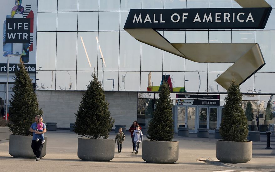 Shoppers, visitors and employees exit the Mall of America on March 17, 2020 as the mall in Bloomington, Minn. The family of a boy who was severely injured when he was thrown off a third-floor balcony at the Mall of America in April 2019 has reached a confidential settlement with the shopping center, which includes making changes to its trespassing policies, the family and mall announced Monday, Dec. 5, 2022.