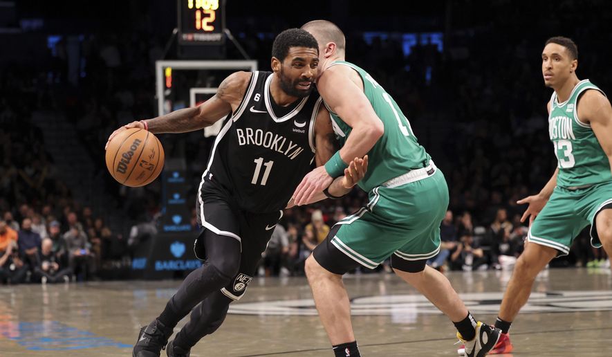 Brooklyn Nets guard Kyrie Irving (11) dribbles against Boston Celtics guard Payton Pritchard (11) as Boston Celtics guard Malcolm Brogdon (13) watches during the second half of an NBA basketball game, Sunday, Dec. 4, 2022, in New York. (AP Photo/Jessie Alcheh)