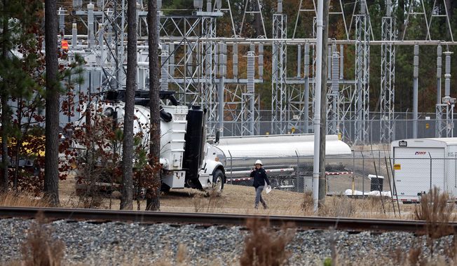 Workers work on equipment at the West End Substation, at 6910 NC Hwy 211 in West End, N.C., Monday, Dec. 5, 2022, where a serious attack on critical infrastructure has caused a power outage to many around Southern Pines, N.C. (AP Photo/Karl B DeBlaker)
