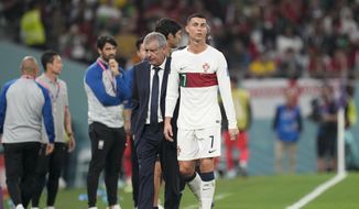 Portugal&#39;s Cristiano Ronaldo, center, passes beside his coach Fernando Santos as he leaves the field during the World Cup group H soccer match between South Korea and Portugal, at the Education City Stadium in Al Rayyan , Qatar, Friday, Dec. 2, 2022. (AP Photo/Lee Jin-man)