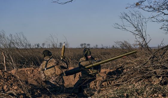 Ukrainian soldiers fire a cannon at Russian positions in the frontline near Bakhmut, Donetsk region, Ukraine, Tuesday, Dec. 6, 2022. (AP Photo/LIBKOS)