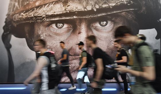 Visitors passing an advertisement for the video game &#39;Call of Duty&#39; at the Gamescom fair for computer games in Cologne, Germany, Tuesday, Aug. 22, 2017. Microsoft says it struck a deal to make the hit video game Call of Duty available on Nintendo for 10 years when its $69 billion purchase of game maker Activision Blizzard goes through. The announcement Wednesday, Dec. 7, 2022 is an apparent attempt to fend off objections from rival Sony.  (AP Photo/Martin Meissner, File)