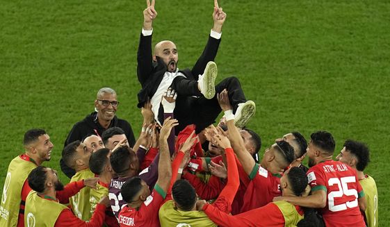 Morocco&#x27;s head coach Walid Regragui is thrown in the air at the end of the World Cup round of 16 soccer match between Morocco and Spain, at the Education City Stadium in Al Rayyan, Qatar, Tuesday, Dec. 6, 2022. (AP Photo/Abbie Parr)