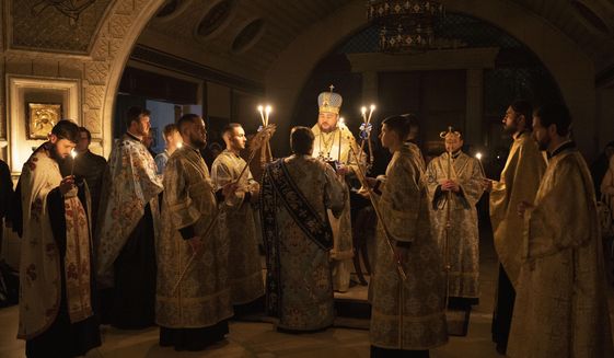 Metropolitan Oleksandr delivers a religious service with clerics inside the Transfiguration of Jesus Orthodox Cathedral during blackout caused by recent Russian rocket attacks, in Kyiv, Ukraine, Saturday, Dec. 3, 2022. A top Orthodox priest in Ukraine&#39;s capital says he supports the efforts of President Volodymyr Zelenskyy&#39;s government and counter-intelligence agency to end Russian spying and meddling in Ukrainian politics through a Moscow-affiliated church. (AP Photo/Efrem Lukatsky)