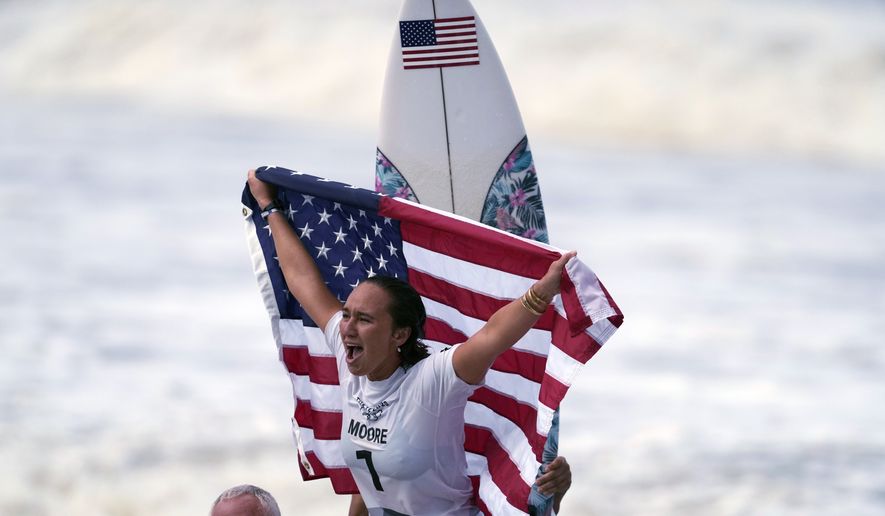 Carissa Moore, of the United States, celebrates winning the gold medal of the women&#x27;s surfing competition at the 2020 Summer Olympics, July 27, 2021, at Tsurigasaki beach in Ichinomiya, Japan. Moore won the AAU James E. Sullivan Award as the nation’s most outstanding college or Olympic athlete. Moore is the first surfer and first native Hawaiian to win the 92nd annual award. She was presented the trophy on Thursday in Honolulu. (AP Photo/Francisco Seco, File)