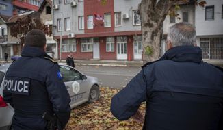 Kosovo police officers guard the offices of the Central Election Committee in ethnically divided town of northern Mitrovica on Friday, Dec. 9, 2022. Kosovo law enforcement on Friday said one officer was injured by gunmen after increasing police presence fearing tension in northern areas dominated by the ethnic Serb minority. (AP Photo/Visar Kryeziu)