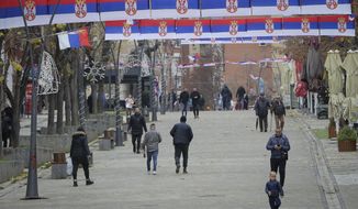 Serb national flags decorate the main square in ethnically divided town Serb dominated northern Mitrovica on Friday, Dec. 9, 2022. Kosovo law enforcement on Friday said one officer was injured by gunmen after increasing police presence fearing tension in northern areas dominated by the ethnic Serb minority. (AP Photo/Visar Kryeziu)