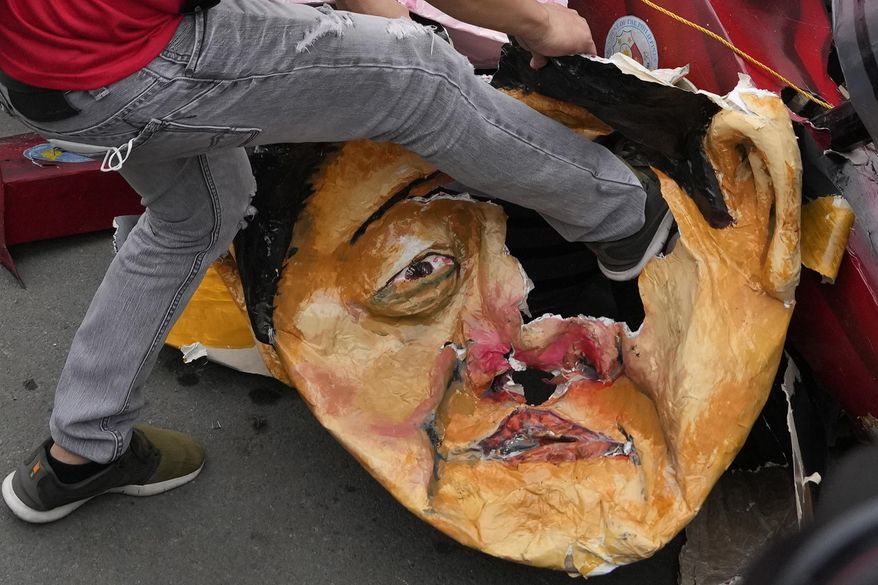A protester kicks an effigy of Philippine President Ferdinand Marcos Jr. during a rally as they commemorate International Human Rights Day, Saturday, Dec. 10, 2022, in Manila, Philippines. Hundreds of people marched in the Philippine capital on Saturday protesting what they said was a rising number of extrajudicial killings and other injustices under the administration of President Ferdinand Marcos Jr. (AP Photo/Aaron Favila)
