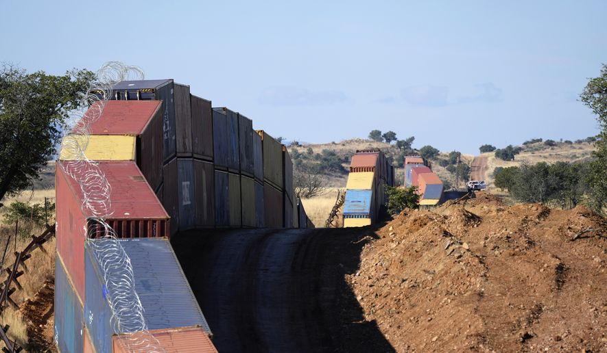 A long row of double-stacked shipping contrainers provide a new wall between the United States and Mexico in the remote section area of San Rafael Valley, Ariz., Thursday, Dec. 8, 2022. (AP Photo/Ross D. Franklin) ** FILE **