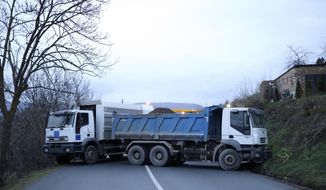 Trucks used as barricade are seen on the road near the village of Rudare, northern Kosovo, Saturday, Dec. 10, 2022. Kosovo has postponed the local election due to be held Dec. 18 in four municipalities with a predominantly ethnic Serb population, in an effort to defuse recent tensions there that have also further damaged relations with neighboring Serbia. President Vjosa Osmani on Saturday decided to postpone the voting until April 23 next year.  (AP Photo/Bojan Slavkovic)