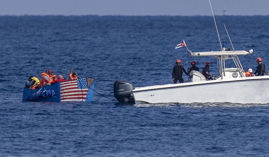 People in a makeshift boat with the U.S. flag painted on the side are captured by the Cuban Coast Guard, seen from the Malecon seawall in Havana, Cuba, Monday, Dec. 12, 2022. (AP Photo/Ramon Espinosa)
