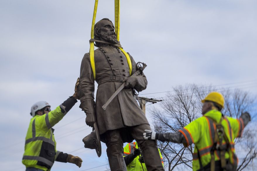 Workers begin to lay the bronze statue of Confederate Gen. A.P. Hill onto a flatbed truck on Monday, Dec. 12, 2022, in Richmond, Va. The city of Richmond — the capital of the Confederacy for most of the Civil War — removed the statue, its last city-owned Confederate statue Monday, more than two years after it began to purge itself of what many saw as painful symbols of racial oppression. (AP Photo/John C. Clark)