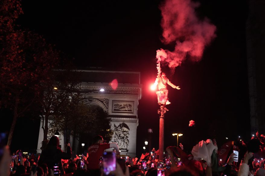 Morocco soccer fans celebrate their team&#x27;s victory on the Champs-Elysees avenue after the World Cup quarterfinal soccer match between Morocco and Portugal Saturday, Dec. 10, 2022, in Paris. (AP Photo/Francois Mori, File)