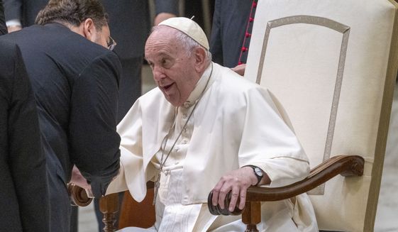 Pope Francis talks to a guest in the Paul VI Hall at The Vatican at the end of his weekly general audience, Wednesday, Dec. 14, 2022. (AP Photo/Domenico Stinellis)