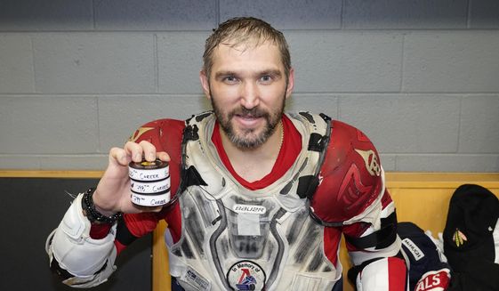 Washington Capitals&#39; Alex Ovechkin holds his 798, 799, and 800th career goal pucks in the locker room after an NHL hockey game against the Chicago Blackhawks Tuesday, Dec. 13, 2022, in Chicago. (AP Photo/Charles Rex Arbogast) **FILE**