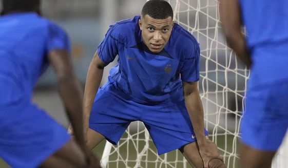 France&#x27;s Kylian Mbappe stretches during a training session in Doha, Qatar, Tuesday, Dec. 13, 2022 on the eve of their World Cup semifinal soccer match against Morocco. (AP Photo/Christophe Ena)