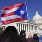 A woman waves the flag of Puerto Rico during a news conference on Puerto Rican statehood on Capitol Hill in Washington, March 2, 2021. The U.S. House has passed a bill that would allow Puerto Rico to hold the first-ever binding referendum on whether to become a state or gain some sort of independence. It is a last-ditch effort that stands little chance of passing the Senate.  (AP Photo/Patrick Semansky, File)