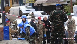 Irish UN peacekeepers and Lebanese soldiers investigate the scene where gunfire came on a UN peacekeeper convoy in the Al-Aqbiya village, south Lebanon, Thursday, Dec. 15, 2022. (AP Photo/Mohammed Zaatari)