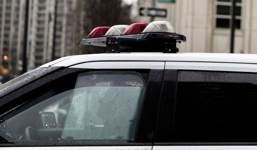 A police officer sits in a car near the Brooklyn Bridge, Friday, Dec. 16, 2022, in the Brooklyn borough of New York. The New York City police department reached a legal settlement Friday that requires it to abandon a practice in which officers use prolonged street stops to check for arrest warrants and ties to other cases, a tactic critics denounced as “digital stop and frisk.” (AP Photo/Julia Nikhinson)