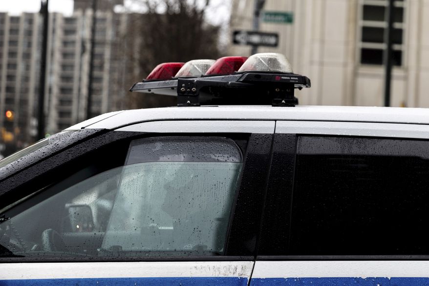 A police officer sits in a car near the Brooklyn Bridge, Friday, Dec. 16, 2022, in the Brooklyn borough of New York. The New York City police department reached a legal settlement Friday that requires it to abandon a practice in which officers use prolonged street stops to check for arrest warrants and ties to other cases, a tactic critics denounced as “digital stop and frisk.” (AP Photo/Julia Nikhinson)