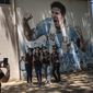 Students graduating from the General Las Heras elementary school, where Lionel Messi also attended school, pose for a group photo wearing their graduation hats by a mural of Messi, on the last day of school in Rosario, Argentina, Wednesday, Dec. 14, 2022. (AP Photo/Rodrigo Abd)