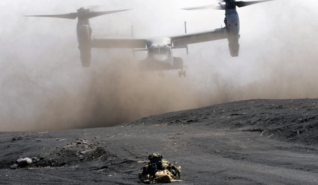 An MV-22 Osprey takes off as Japan Ground Self-Defense Force guards the landing zone during a joint military drill with U.S. Marines in Gotemba, southwest of Tokyo, on March 15, 2022. In a major break from its strictly self-defense-only postwar principle, Japan adopted a national security strategy Friday, Dec. 16, 2022, declaring plans to possess preemptive strike capability and cruise missiles within years to give itself more offensive footing against threats from neighboring China and North Korea. (AP Photo/Eugene Hoshiko, File)