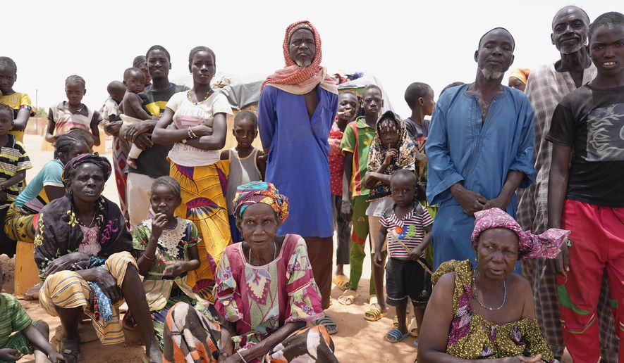 FILE - Internally displaced people wait for aid in Djibo, Burkina Faso, on May 26, 2022. More than 25,000 people will face starvation in conflict-plagued parts of West Africa next year, a United Nations official warned Friday, Dec. 16, 2022. Populations in Nigeria, Mali and Burkina Faso will be in phase five catastrophic hunger by June driven largely by violence as well as economic impacts from the fallout of COVID-19 and the war in Ukraine, said the United Nations Friday. (AP Photo/Sam Mednick)