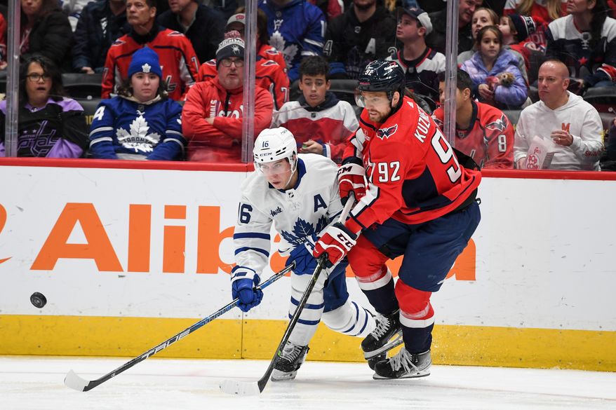 Washington Capitals center Evgeny Kuznetsov (92) fighting for the puck with Toronto Maple Leafs right wing Mitchell Marner (16) during the 2nd period in an NHL game at Capital One Arena in Washington D.C., December 17, 2022. (Photo by Billy Sabatini)