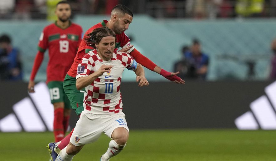 Croatia&#x27;s Luka Modric, front, duels for the ball with Morocco&#x27;s Hakim Ziyech during the World Cup third-place playoff soccer match between Croatia and Morocco at Khalifa International Stadium in Doha, Qatar, Saturday, Dec. 17, 2022. (AP Photo/Frank Augstein)