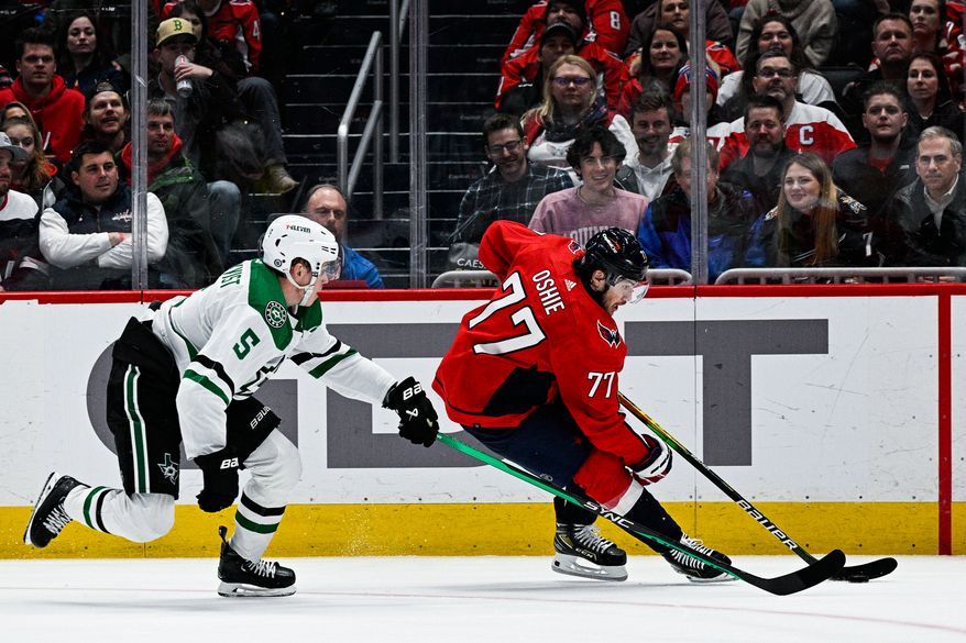 Washington Capitals right wing T.J. Oshie (77) shields the puck against the Dallas Stars at Capital One Arena, Washington, D.C., December 15, 2022. (Photo by Brian Murphy)