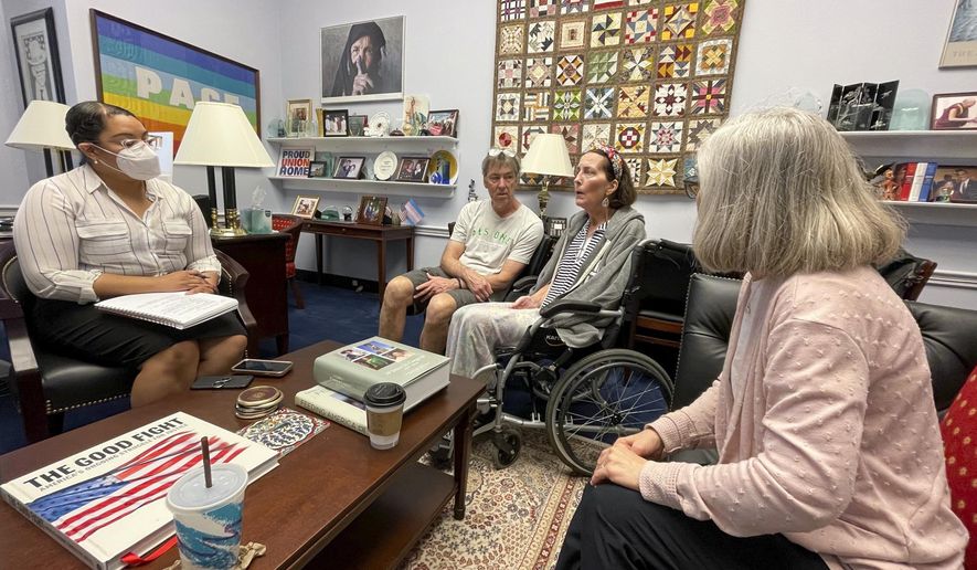 In this photo provided by Becky Mourey, Becky Mourey, center, and her husband Jim, left, meet with representatives for Illinois Rep. Jan Schakowsky at her offices on Capitol Hill, Washington DC in May 2022. Mourey and other ALS patients spent more than two years advocating for the approval of the new drug, Relyvrio, a treatment for ALS. Patients say they are now facing insurance and financial hurdles to access the drug, which costs $158,000. (Nicole Cimbura via AP)