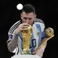 Argentina&#39;s Lionel Messi lisses the trophy after winning the World Cup final soccer match between Argentina and France at the Lusail Stadium in Lusail, Qatar, Sunday, Dec. 18, 2022. Argentina won 4-2 in a penalty shootout after the match ended tied 3-3. (AP Photo/Martin Meissner)
